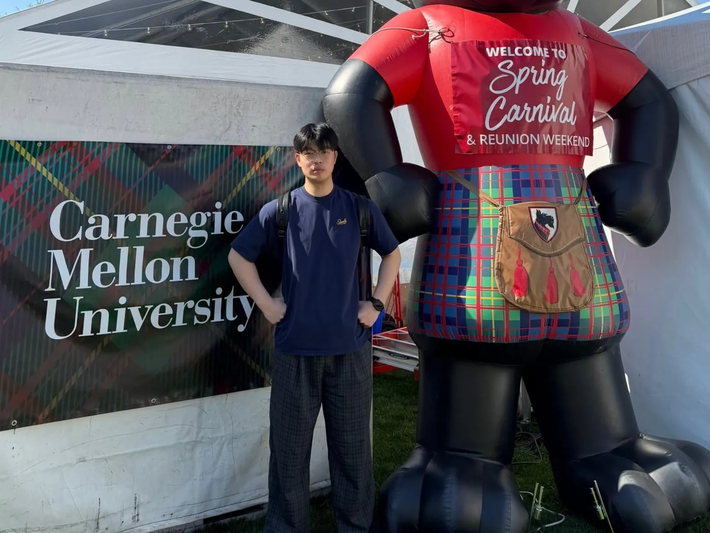 Standing by the Carnegie Mellon banner and the Scotty mascot at Spring Carnival